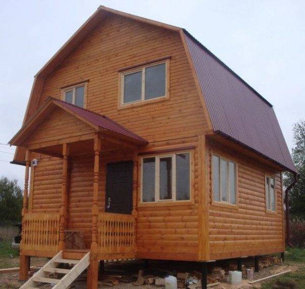 На фото - деревянный дом с крыльцом на столбчатом фундаменте